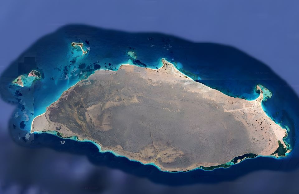 Top-down view of the whole of Isla La Tortuga and its cays, ringed by turquoise reefs